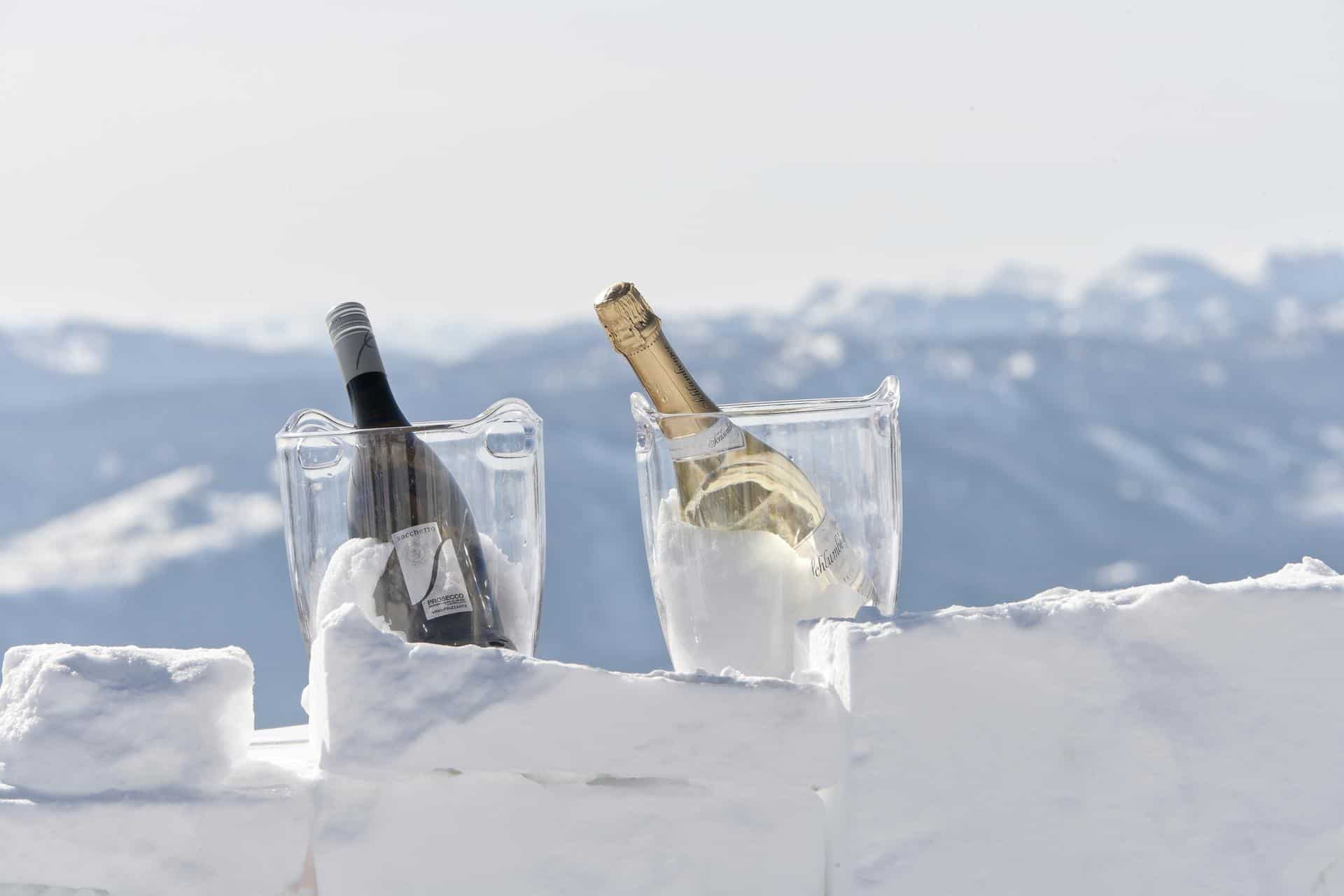 Zwei Sektkübeln auf einer Eisbar mit Berglandschaft